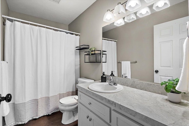 full bathroom featuring vanity, wood finished floors, toilet, and curtained shower