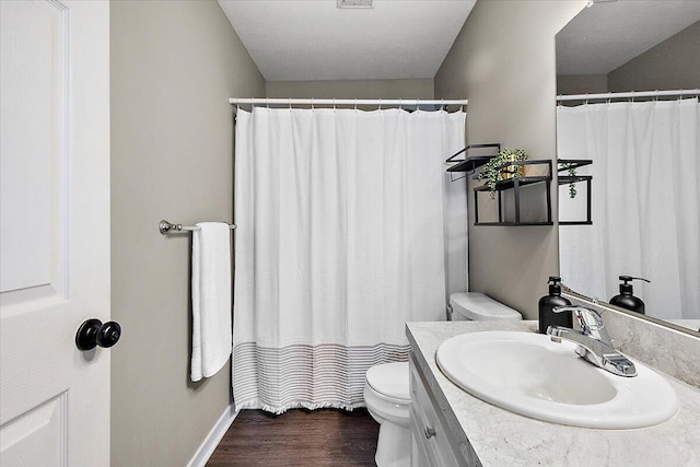full bathroom featuring vanity, visible vents, wood finished floors, toilet, and baseboards