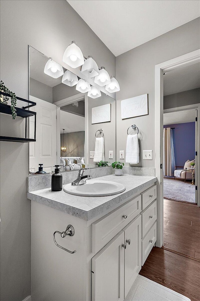 bathroom with wood finished floors, ensuite bathroom, and vanity