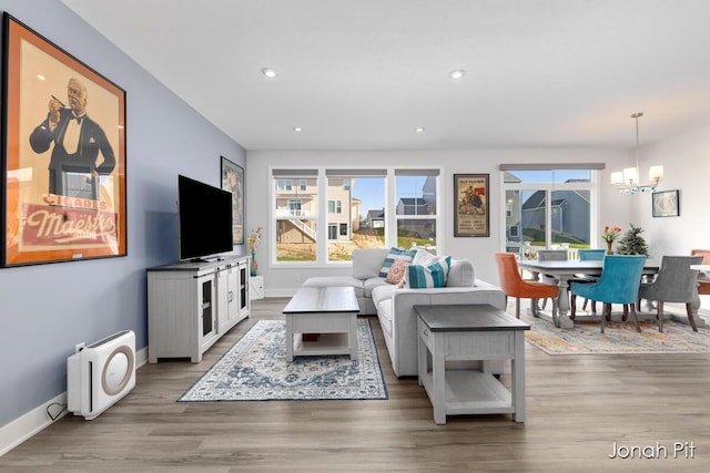 living room featuring baseboards, recessed lighting, wood finished floors, and a chandelier