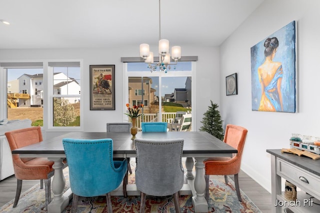 dining room with an inviting chandelier, baseboards, and wood finished floors