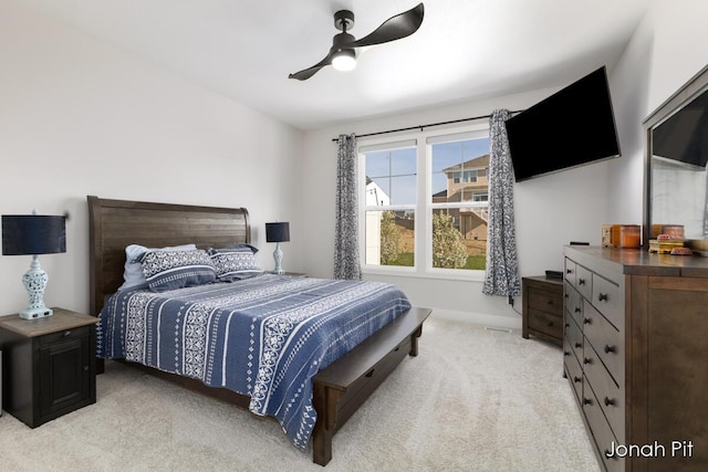 bedroom with ceiling fan, light colored carpet, and baseboards
