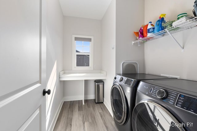 washroom with light wood-style floors, separate washer and dryer, baseboards, and laundry area