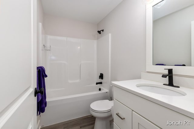 full bath with vanity, washtub / shower combination, wood finished floors, and toilet