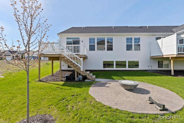 rear view of property with a lawn, a wooden deck, a patio area, and stairway