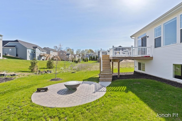 view of yard featuring a residential view, a wooden deck, a patio area, stairway, and an outdoor fire pit