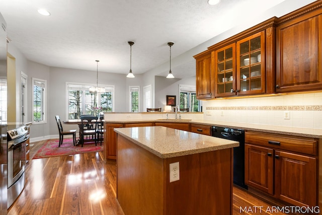 kitchen featuring light stone counters, a sink, dark wood finished floors, black dishwasher, and a peninsula