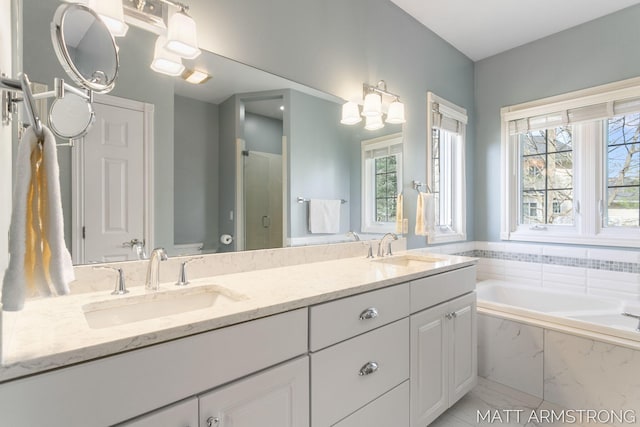 bathroom with a sink, a bath, a stall shower, and a wealth of natural light