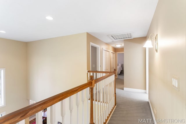 hallway featuring visible vents, baseboards, an upstairs landing, light carpet, and recessed lighting