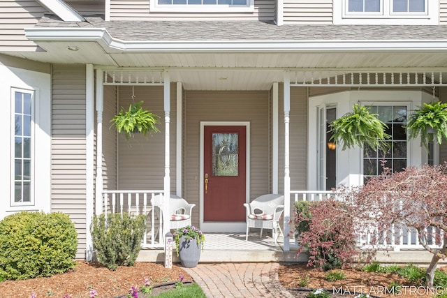 property entrance featuring a shingled roof and a porch