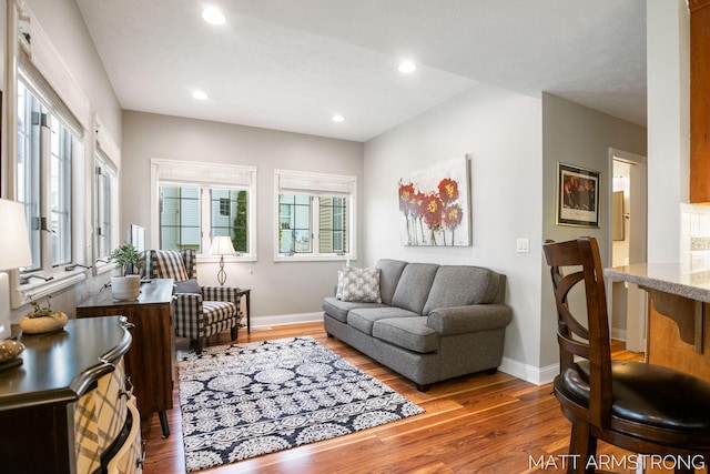 living area featuring baseboards, recessed lighting, and wood finished floors