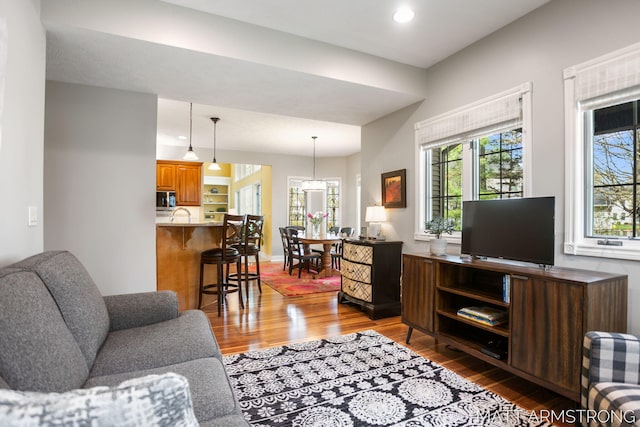 living room with recessed lighting, wood finished floors, and a wealth of natural light