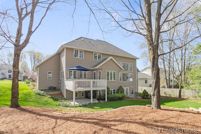 back of property with a lawn, a deck, fence, and central air condition unit
