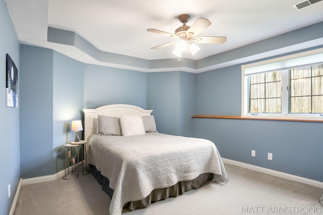 carpeted bedroom with visible vents, a ceiling fan, and baseboards