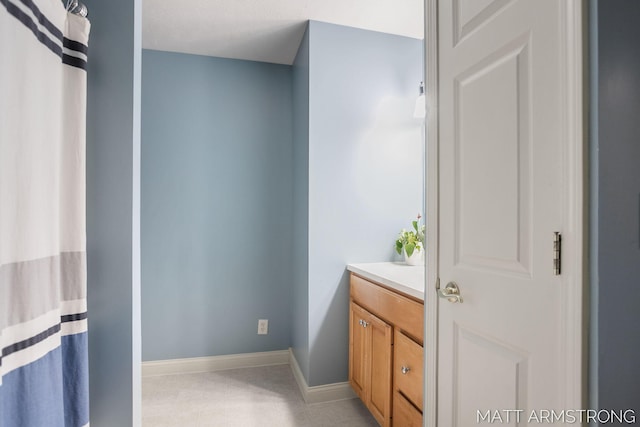 full bath with vanity and baseboards