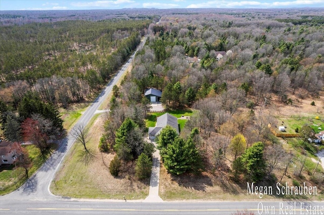 bird's eye view with a wooded view