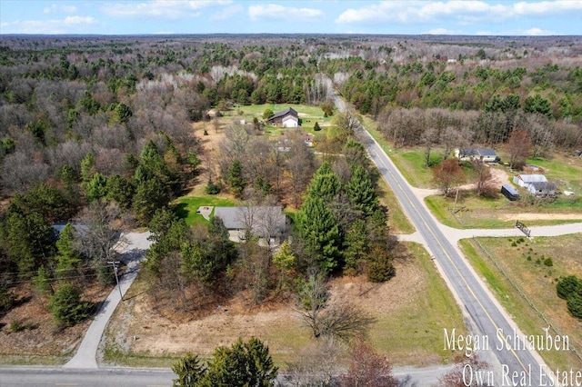 drone / aerial view featuring a wooded view