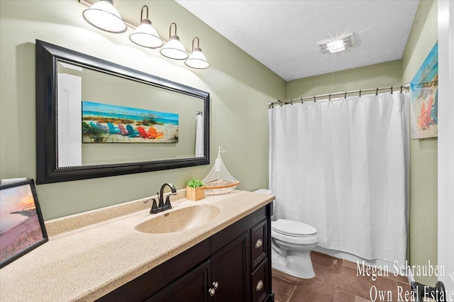 bathroom featuring vanity, tile patterned floors, toilet, and curtained shower