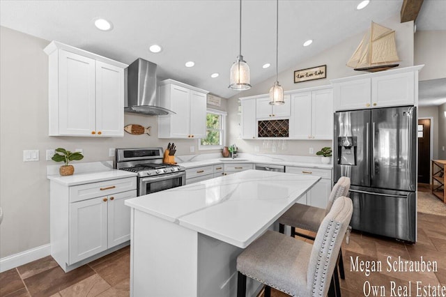 kitchen featuring a kitchen island, white cabinets, appliances with stainless steel finishes, and wall chimney exhaust hood