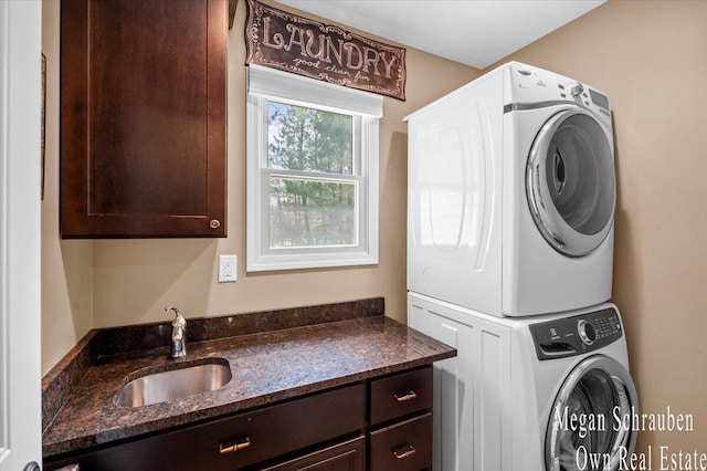 laundry room with a sink, cabinet space, and stacked washing maching and dryer
