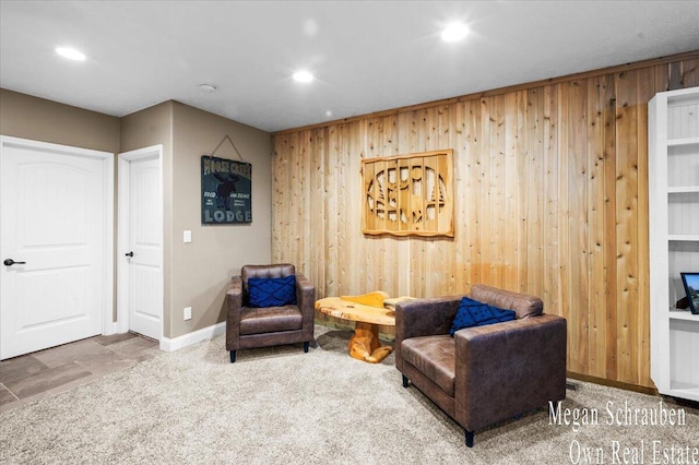 living area featuring recessed lighting, carpet flooring, baseboards, and wooden walls