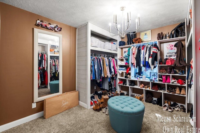 walk in closet with an inviting chandelier and carpet