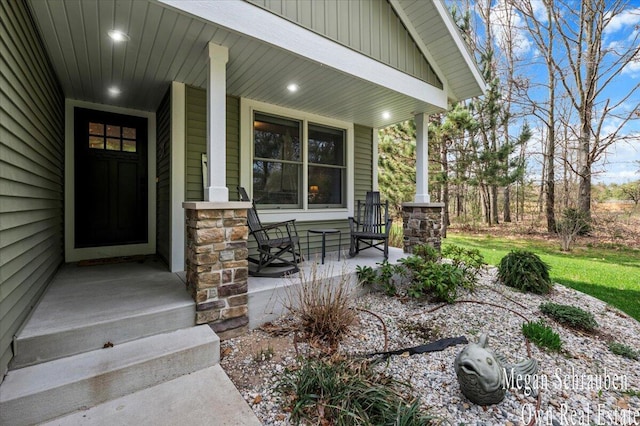 entrance to property featuring a porch and stone siding