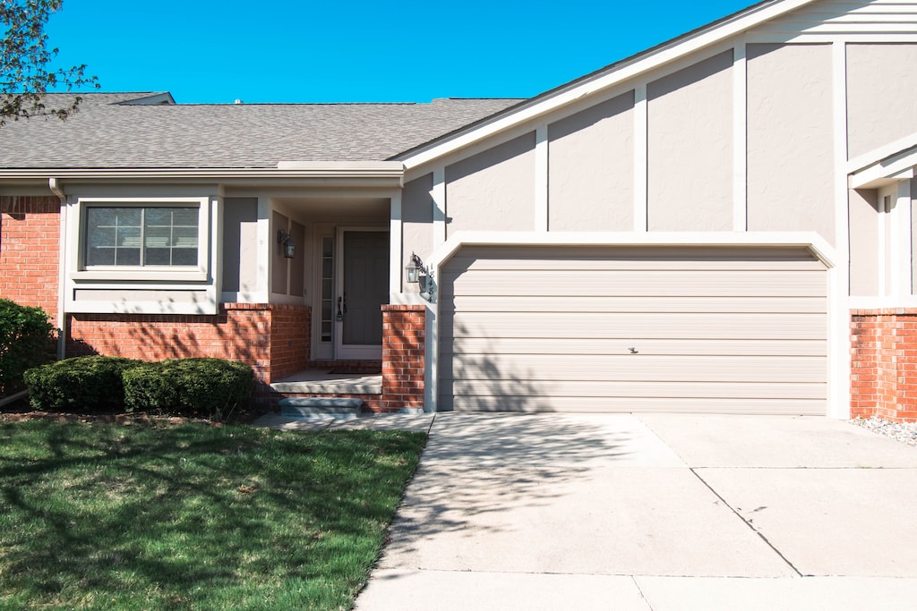 18484 Brookside Ln, Clinton Township, MI 48038 - view of front of property featuring concrete driveway, brick siding, an attached garage, and a shingled roof