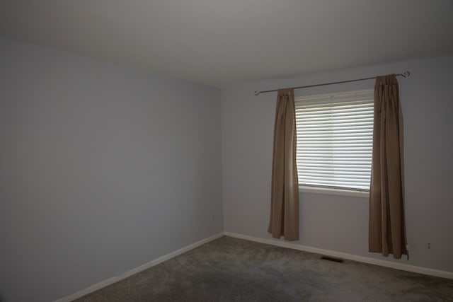 carpeted spare room with baseboards and visible vents