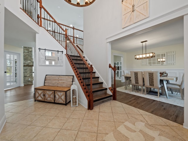 7136 N Meadows Trl, Dexter, MI 48130 - tiled entryway with an inviting chandelier, baseboards, a high ceiling, and stairway