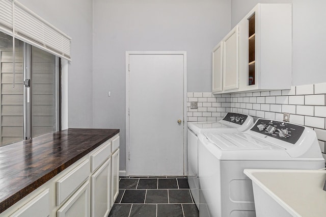 clothes washing area featuring cabinet space, a sink, and washer and dryer