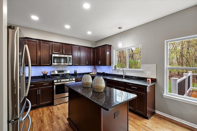 29816 Trailwood Dr, Warren, MI 48092 - kitchen featuring stainless steel appliances, a sink, backsplash, light wood finished floors, and dark stone counters
