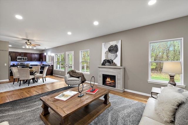 29816 Trailwood Dr, Warren, MI 48092 - living room featuring recessed lighting, light wood-style floors, baseboards, a warm lit fireplace, and a ceiling fan