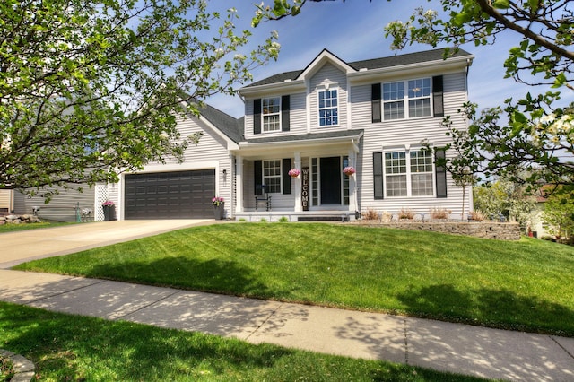 view of front facade with a porch, a garage, driveway, and a front yard