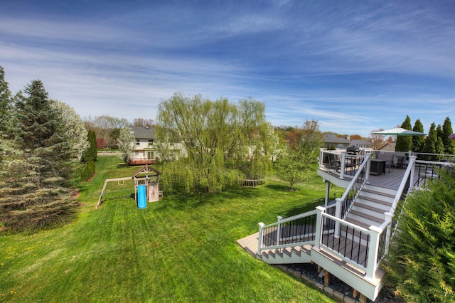 view of yard featuring outdoor dining area, a playground, and a deck