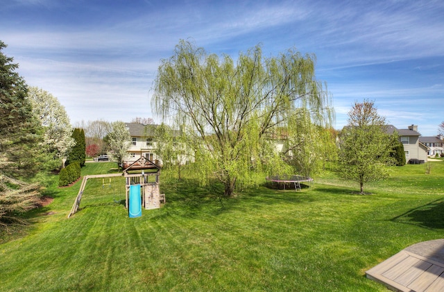 view of yard featuring a trampoline and a playground