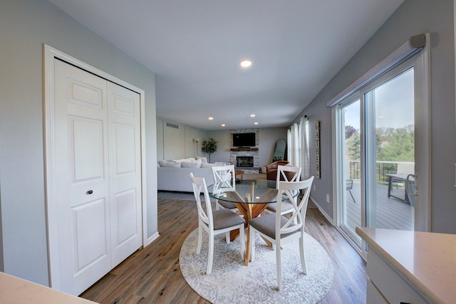 dining area with recessed lighting, visible vents, wood finished floors, and a fireplace