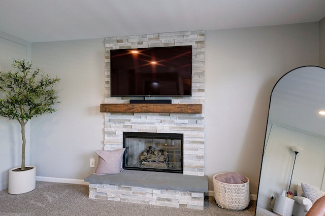 room details with carpet floors, baseboards, and a stone fireplace