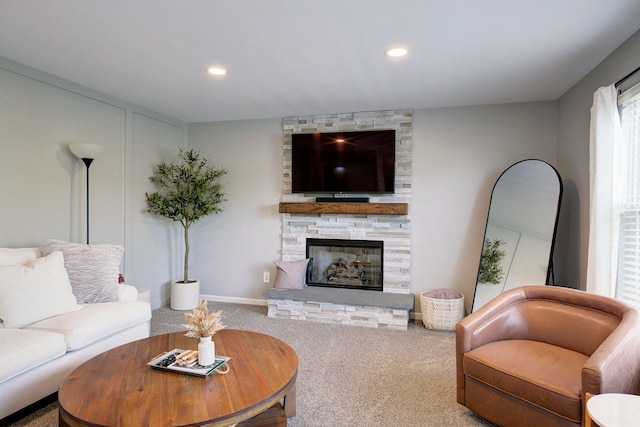 living room with recessed lighting, baseboards, a stone fireplace, and carpet
