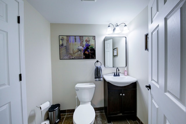 bathroom with vanity, baseboards, and toilet