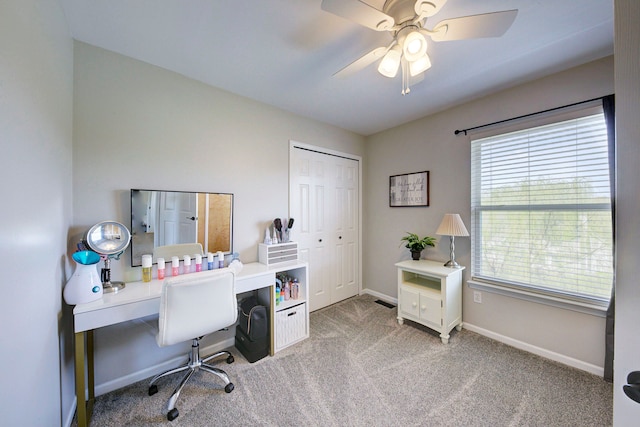 office space featuring baseboards, light colored carpet, and ceiling fan