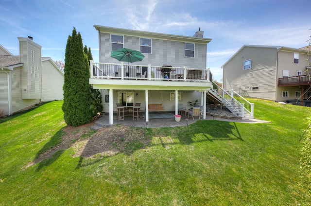 rear view of house with a lawn, stairs, a patio area, and a deck