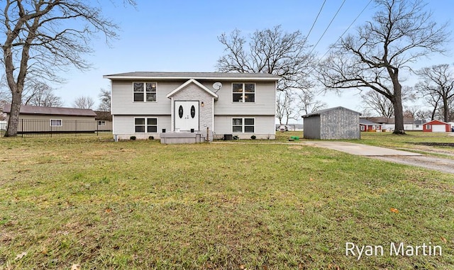 bi-level home featuring fence, an outdoor structure, and a front yard