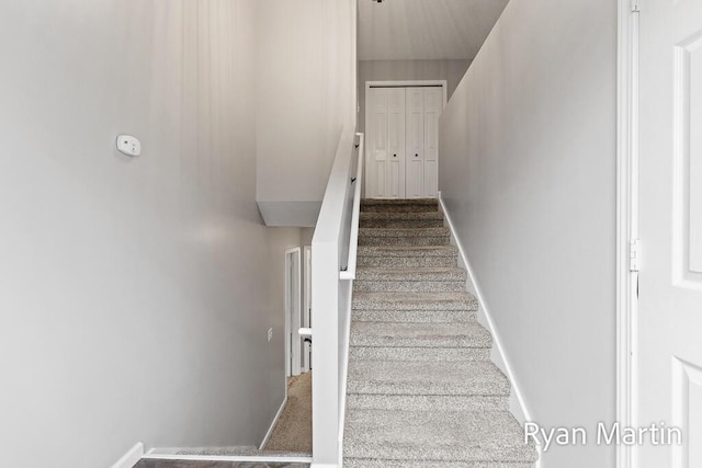 stairs featuring baseboards and carpet