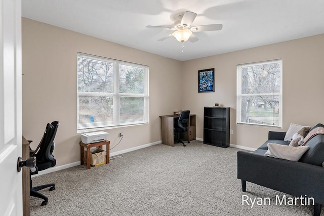 carpeted home office with baseboards and a ceiling fan