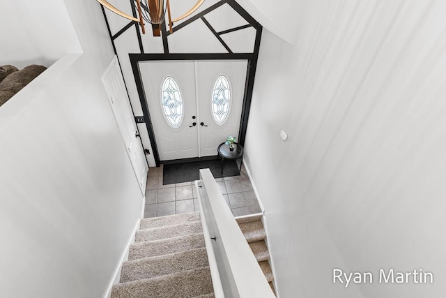 tiled foyer with baseboards and stairs