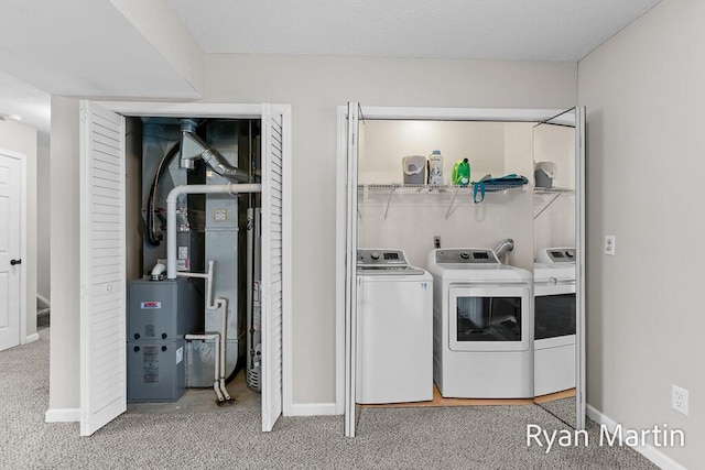 laundry room featuring washing machine and clothes dryer, laundry area, carpet floors, and baseboards