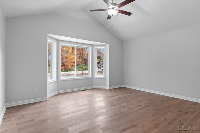 spare room with ceiling fan, baseboards, wood finished floors, lofted ceiling, and visible vents