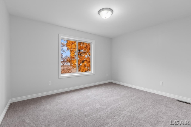 carpeted empty room with baseboards and visible vents