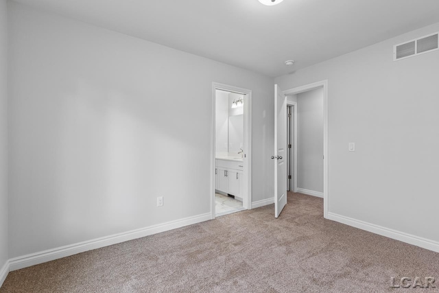 unfurnished bedroom with baseboards, light colored carpet, and visible vents